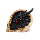 Side profile of a black dragon figurine with prominent red eyes and horns, emerging from a bone-coloured skull.