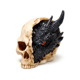Angled view of a black dragon figurine with a single red eye and dark scales emerging from a beige skull ornament.