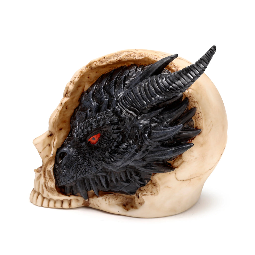 Angled side view of a large black dragon figurine with bright red eyes and horns, its head emerging from a cream-coloured skull ornament.