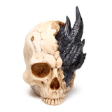 Angled view of a large ornamental figurine depicting a cracked, beige human skull with a black, scaly dragon emerging from its right side.