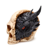 Angled view of a black dragon head ornament with red eyes and prominent horns, emerging from a beige, cracked human skull.