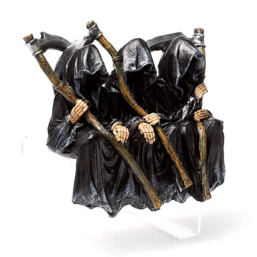 Front view of a decorative ornament depicting three reapers in black cloaks with skeletal hands, holding scythes and seated on a bench.