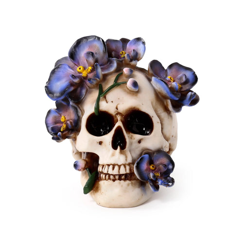 Front view of a cream skull ornament, adorned with purple vine flowers and yellow centres.