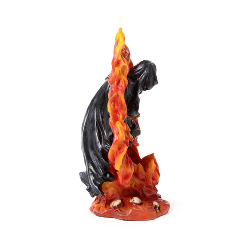 Resin tea light holder showing the side profile of a dark, cloaked Reaper figure surrounded by vibrant orange and yellow flames, with small skulls at its base.