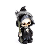 Front view of a decorative grim reaper mini skull ornament, in a black hooded robe and holding a silver scythe.