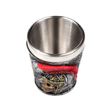 Angled overhead view of a decorative shot glass with a silver-coloured inner, featuring an embossed grey Roman soldier helmet with a red plume, gold detailing, and a skull.