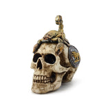 Angled view of a decorative scorpion skull ornament, bone-coloured with carved astrological symbols, featuring a golden scorpion resting on its crown and a circular gold and grey emblem on its temple.