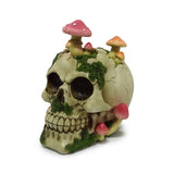 Angled view of a decorative skull ornament, featuring a weathered surface, red and orange toadstools, and green moss.
