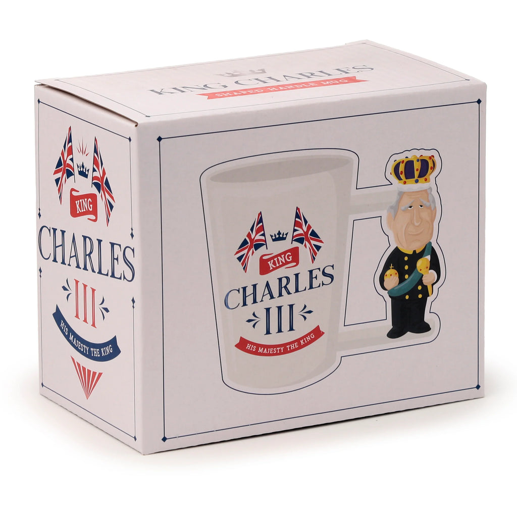 Angled view of the white gift box for a novelty ceramic King Charles III shaped handle mug. The packaging shows an illustration of the mug with a cartoon King Charles III figure forming the handle, complete with crown and royal regalia. Union Jack flags and 'King Charles III' text are also printed on the box's visible panels.