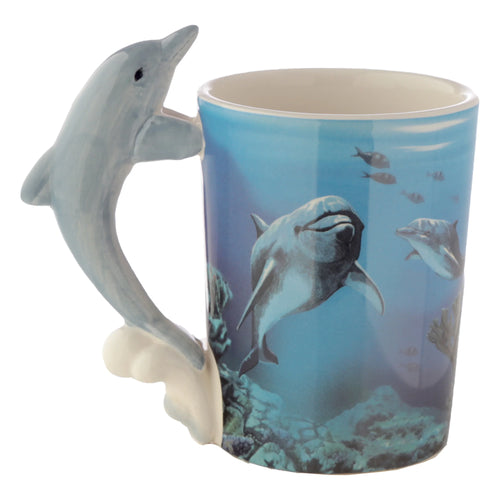 Angled view of a ceramic mug with a pale blue dolphin-shaped handle. Its body features an underwater scene of swimming dolphins and marine life. Cream interior.