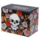 Angled view of a black rectangular packaging box for a Skeleton Ceramic Shaped Handle Mug, featuring a white skull design surrounded by red, pink, and light grey roses with orange foliage, and 'Skulls & Roses' text on its top surface.