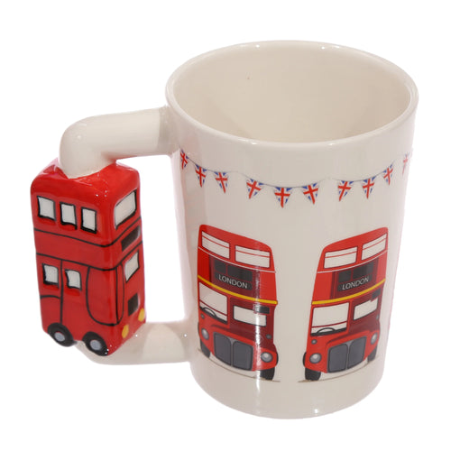 Angled view of a white ceramic mug with a red Routemaster London bus-shaped handle, featuring illustrations of red double-decker buses and Union Jack bunting.