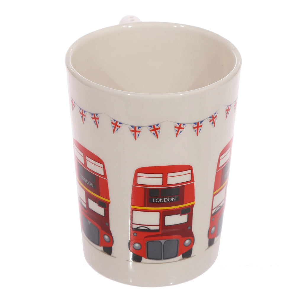 Angled view of a white ceramic mug, featuring a repeating pattern of red London Routemaster buses with 'LONDON' signs, and Union Jack bunting along the top rim.