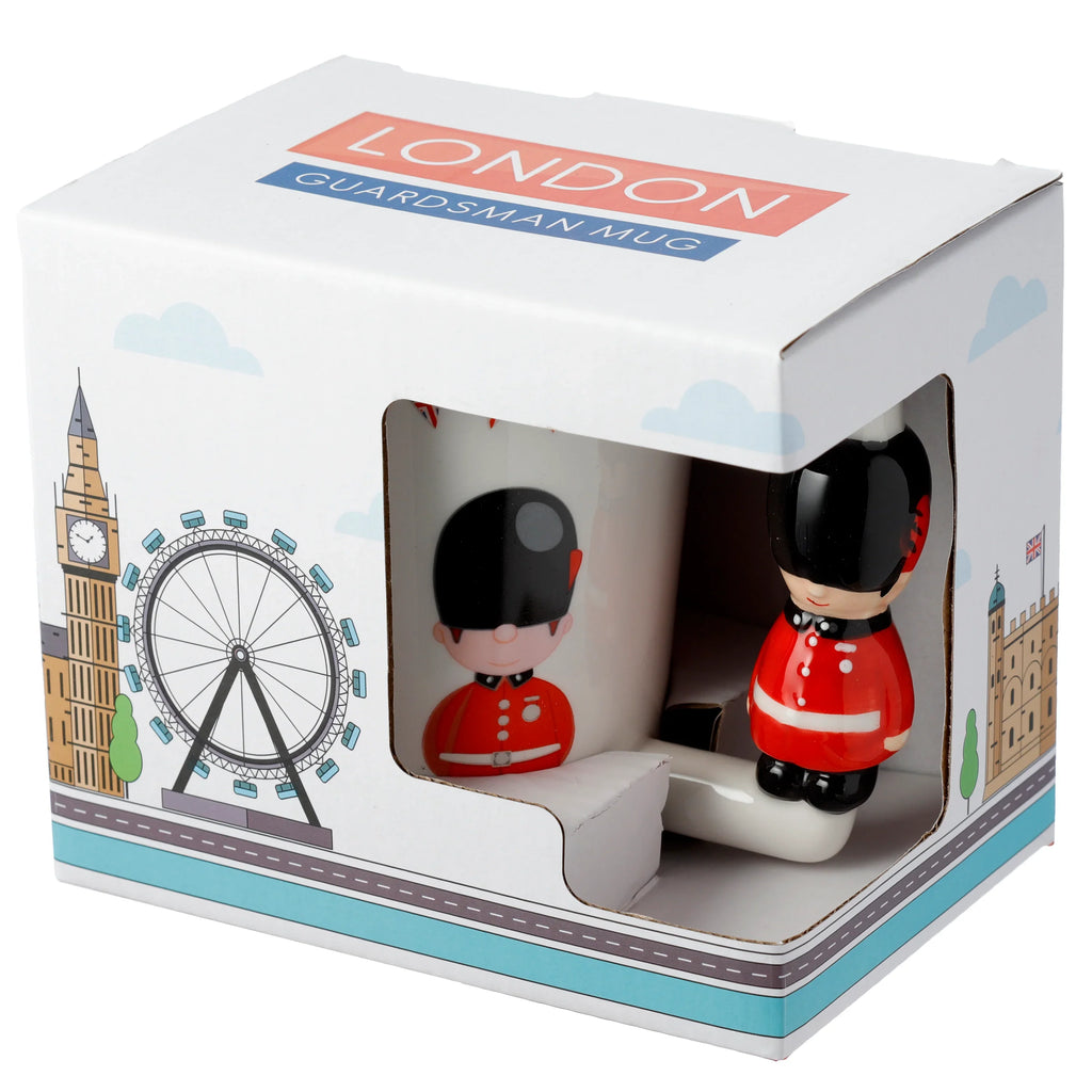 Angled view of a Guardsman figure ceramic shaped handle mug in its white retail box, featuring London landmark illustrations and 'LONDON GUARDSMAN MUG' text, with the red-uniformed figure handle visible.