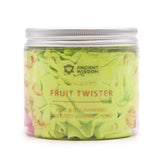 Front view of a clear plastic whipped soap jar with a metallic silver ribbed lid. It contains light green, swirled whipped soap. The label on the front indicates 'Fruit Twister' and 'Kiwi & Strawberry scented whipped soap', with faint illustrations of strawberries and kiwi fruit.