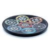 Angled top view of a dark, round soapstone incense burner dish with seven engraved, colourful chakra symbols.