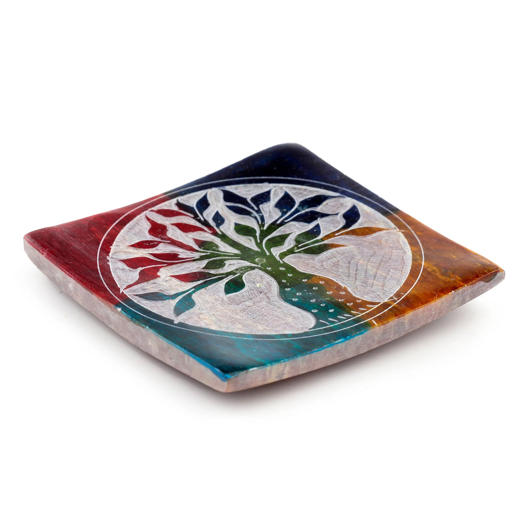 Angled view of a vibrant multi-coloured soapstone incense burner dish, featuring an intricate white Tree of Life carving.