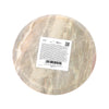 Underside view of a circular soapstone incense burner dish, displaying its natural variegated patterns in shades of grey, beige, and light pink, with a white product label and barcode adhered to the centre.