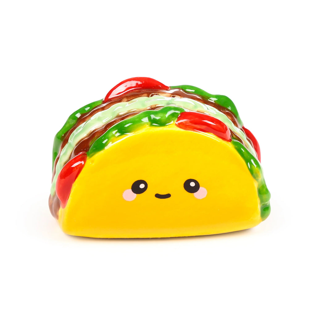 Front view of a yellow ceramic taco salt or pepper shaker with glossy green, brown, and red details, featuring a cute cartoon face.