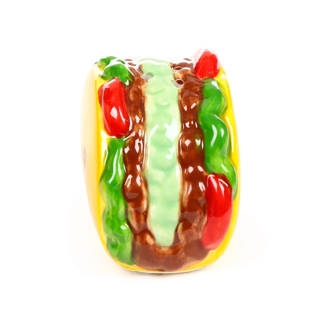 Angled top view of a ceramic taco shaker, with yellow shell and glossy green, brown, and red filling.