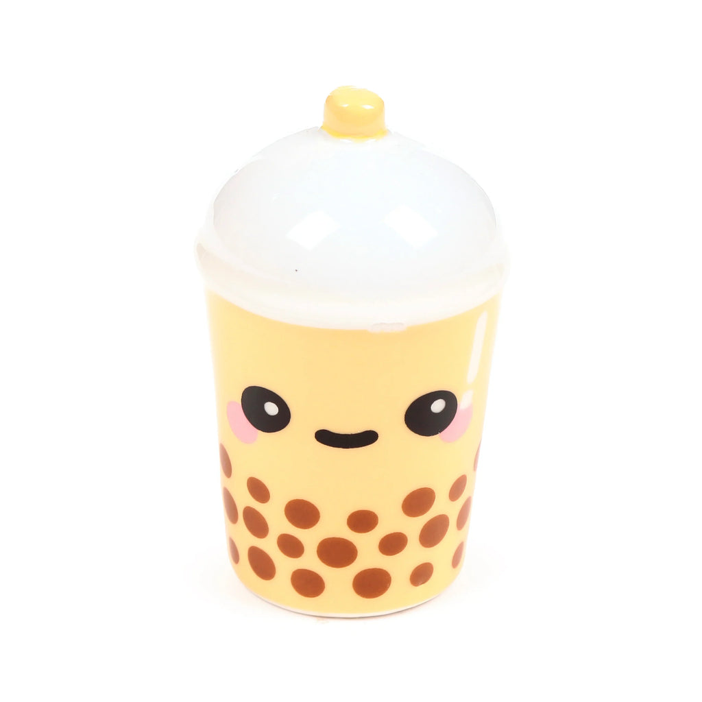 Pale yellow ceramic boba tea cup salt shaker from a front angle, featuring a cute smiling face with pink cheeks, brown 'boba' dots, a white domed lid, and a small yellow straw.