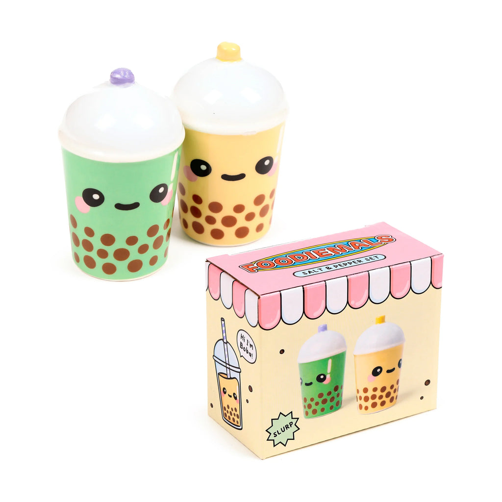 Angled view of a ceramic boba and matcha bubble tea salt and pepper set, featuring green and yellow cartoon-faced shakers with brown dots, displayed alongside its colourful box with 'FOODIEMALS' text.