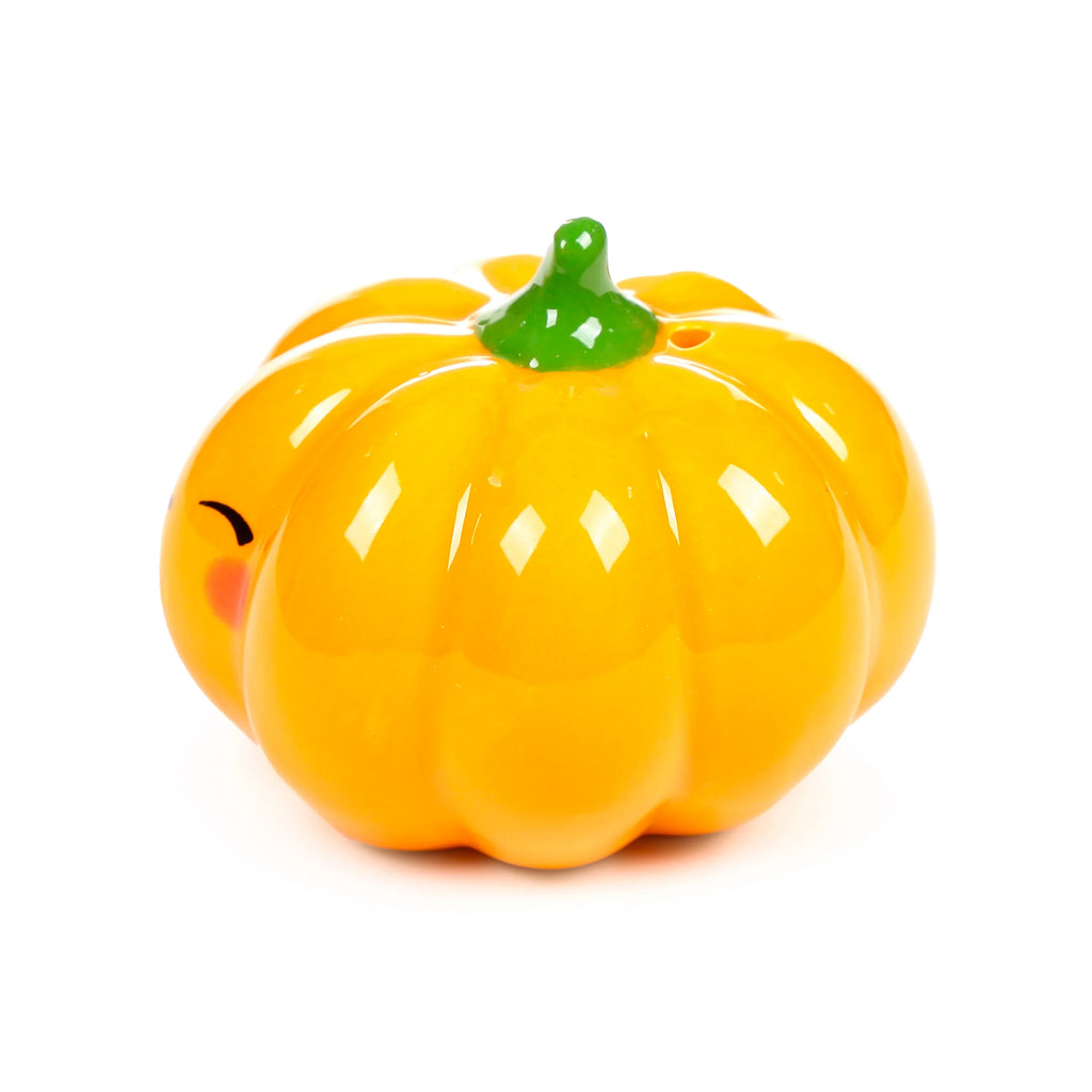 Angled view of a ceramic pumpkin salt and pepper shaker, featuring a glossy orange-yellow colour, green stem, and a small winking face detail on the side.