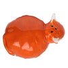 Angled view of a glossy orange ceramic Highland Coo cow salt or pepper shaker, featuring white horns, snout, and three dispensing holes.