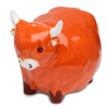 Angled shot of a glossy orange ceramic Highland coo cow salt or pepper shaker, featuring white horns, dark eyes, a white snout, and dark brown feet.