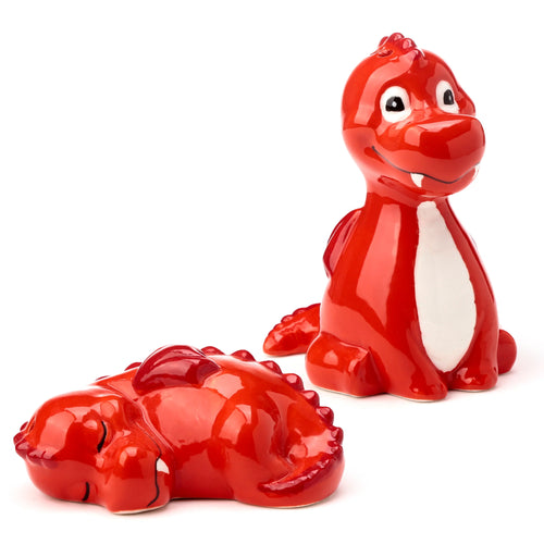 Angled view of a novelty ceramic red dragon salt and pepper set, featuring a standing and a lying glossy red dragon with white bellies.