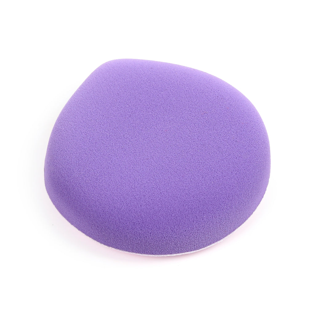 Angled view of a single purple makeup sponge, showing its rounded shape and porous texture on a white background.
