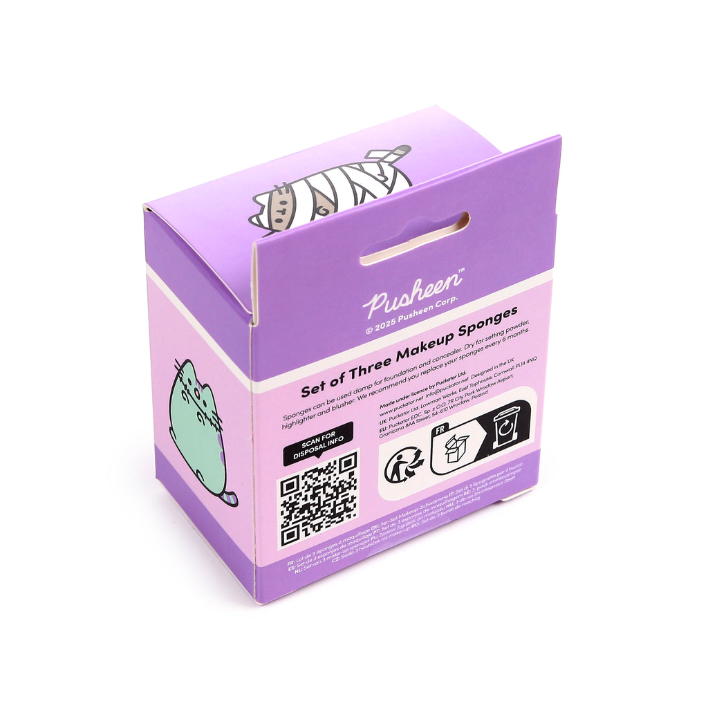 Angled view of purple Pusheen the Cat Halloween makeup sponges packaging. The box features a mummy Pusheen on the lid and a green Pusheen character on the side, with product information for the set of three beauty sponges.