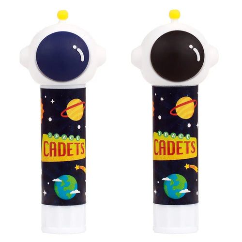 Front view of two colourful glue sticks, each topped with a white astronaut helmet-shaped cap, one featuring a dark blue visor and the other a black visor, both with a small yellow antenna. The body of the glue sticks is decorated with a dark blue space theme, depicting stars, planets, shooting stars, and the yellow text 'SPACE CADETS'.