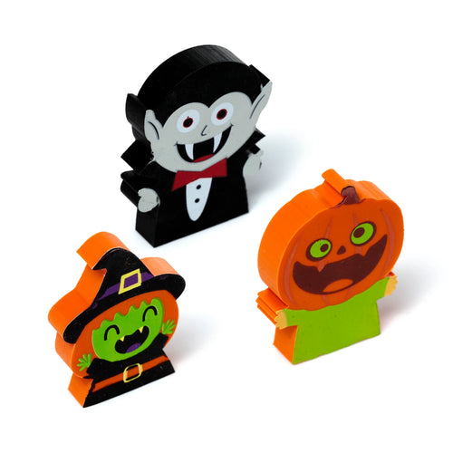 Angled view of a Halloween eraser three-piece set, featuring a black vampire with red eyes, a green-faced witch in a black hat, and an orange pumpkin with a carved smile, all on a white background.
