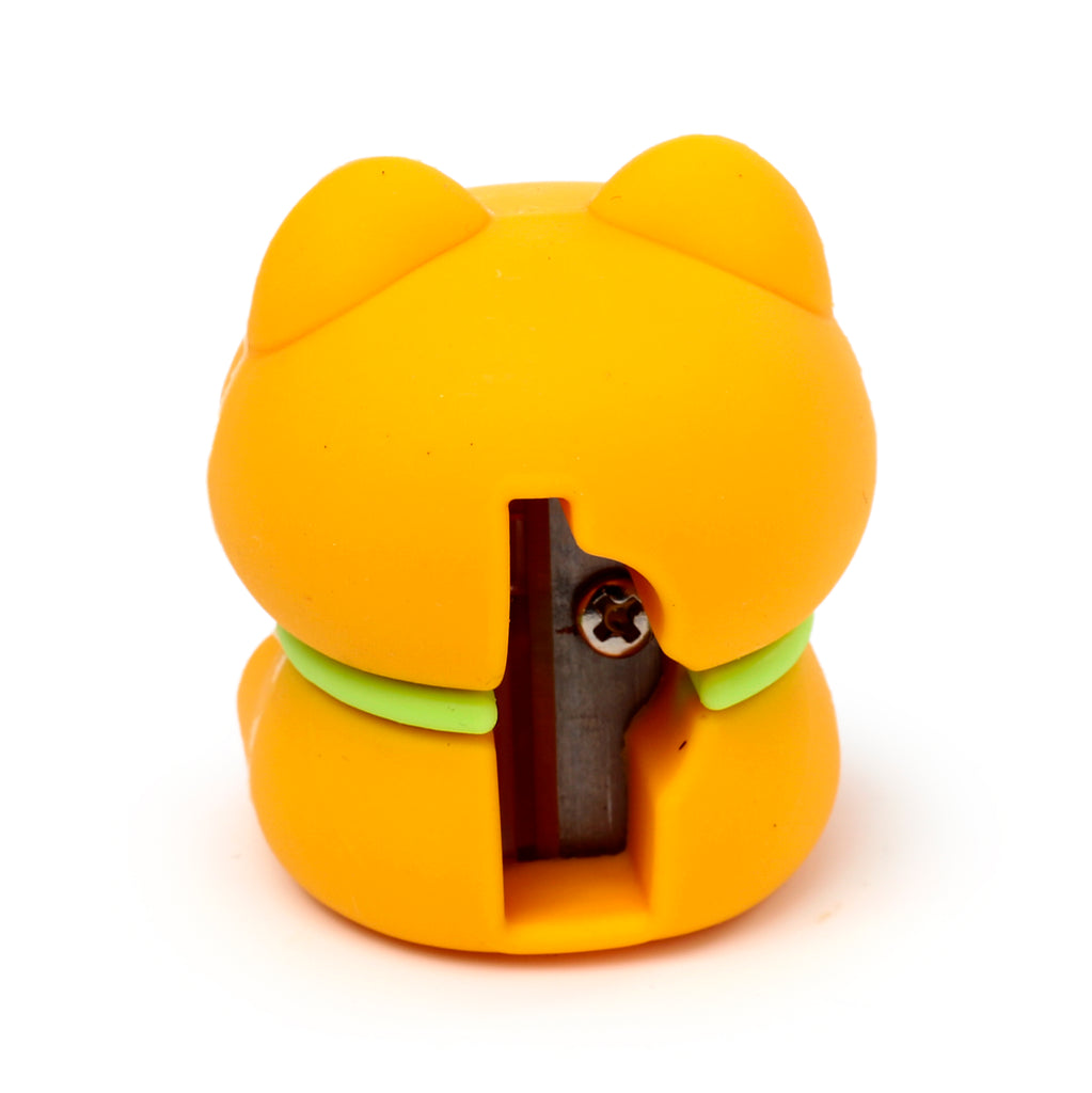 Close-up of an orange and light green Shiba Inu dog-shaped pencil sharpener, showing its sharpener blade and screw mechanism.