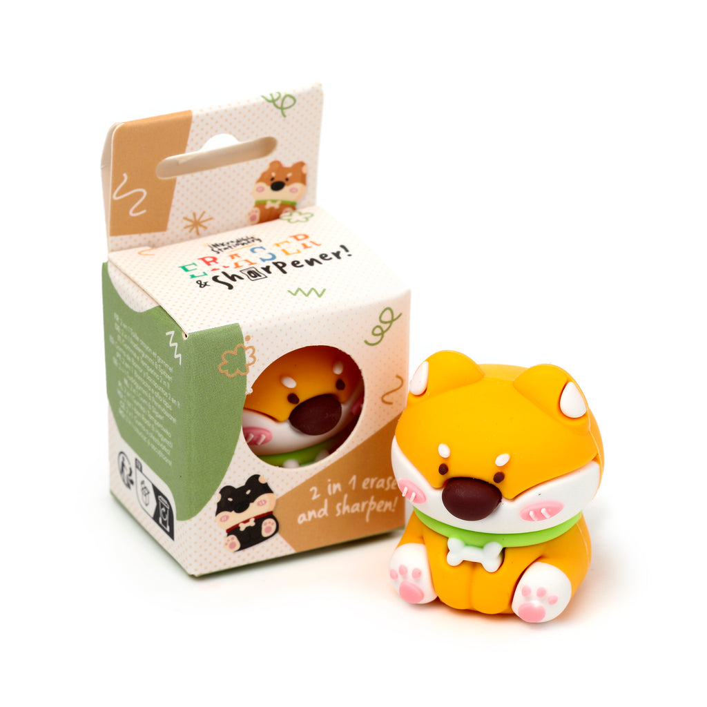 Angled view of a Shiba Inu dog 2-in-1 pencil sharpener and eraser, with orange and white colouring, pink cheeks, green collar, and pink paw pads, next to its open, illustrated retail packaging.
