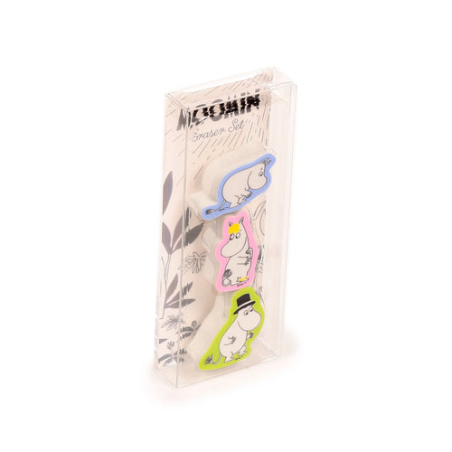 Angled front view of a Moomin Garden eraser set, featuring three white Moomin character erasers with blue, pink, and lime green details, housed in clear plastic packaging.