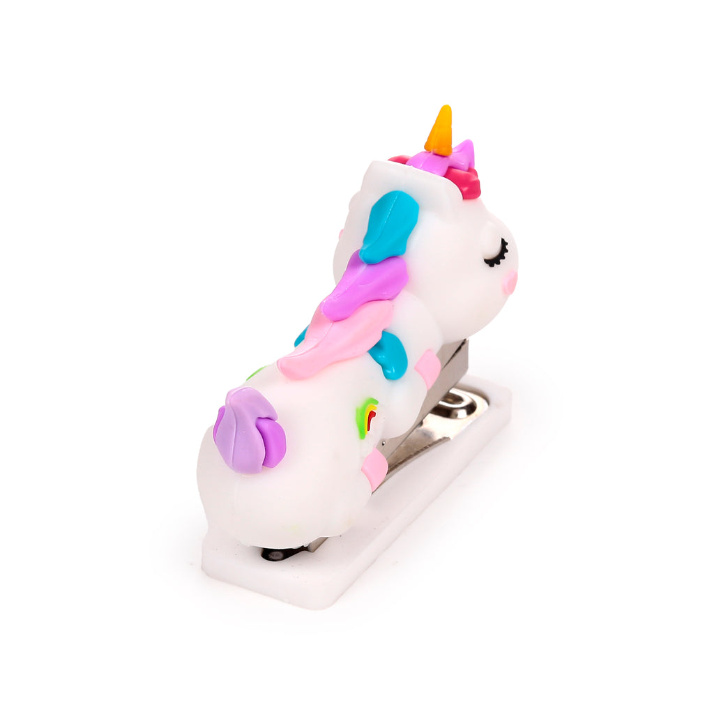 Angled view of a white unicorn mini stapler, showcasing its colourful pink, blue, and purple mane, a yellow horn, closed eyes with eyelashes, a pink nose, and rainbow stripe details on its side, against a white background.