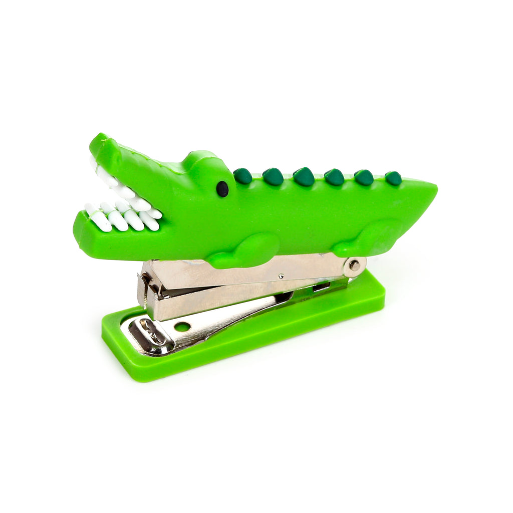 Angled view of a bright green mini crocodile stapler with an open mouth showing white teeth and dark green scales on its back.