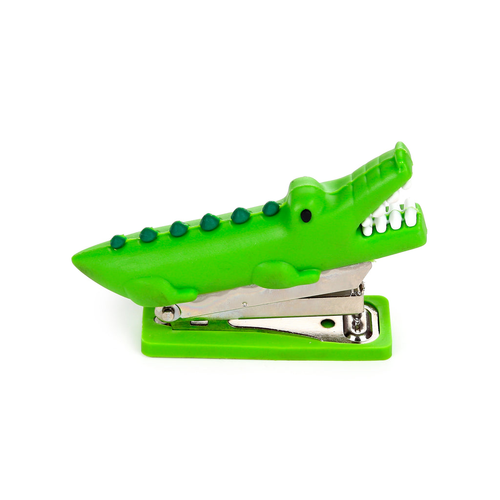 Side view of a bright green mini crocodile stapler with an open mouth, white teeth, and raised back details.