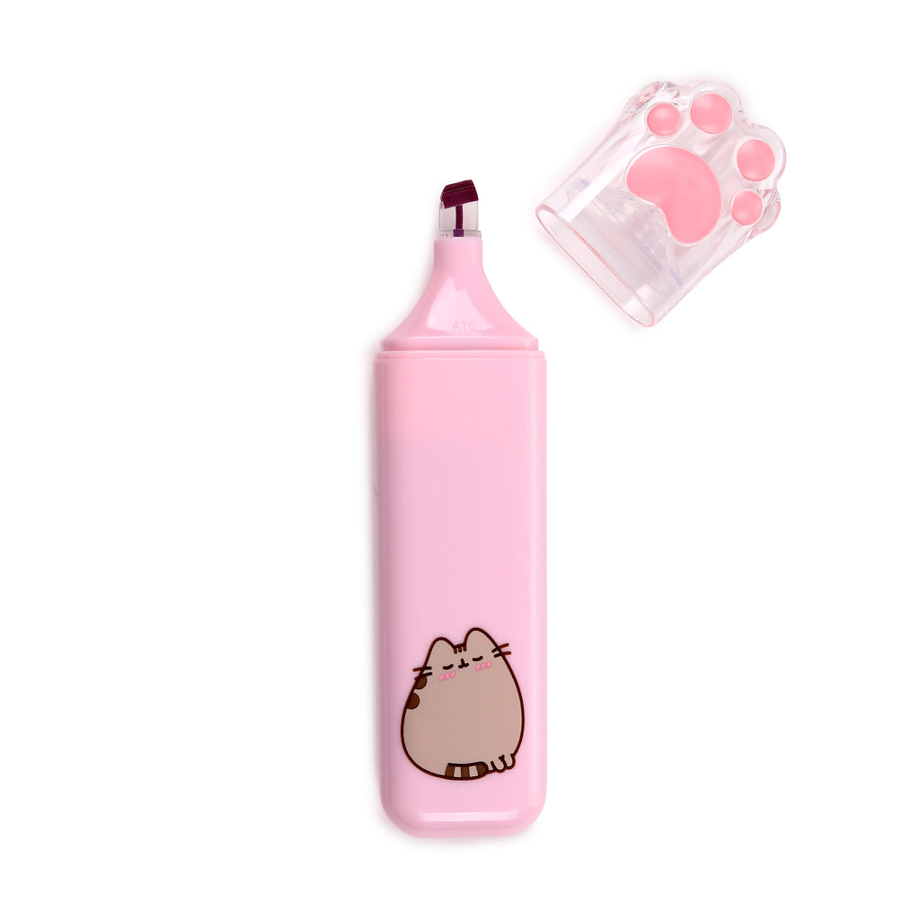 Angled overhead view of a pink highlighter featuring a sleeping Pusheen the Cat illustration, with its clear, paw-print cap removed and placed beside it, revealing the dark pink nib.