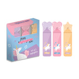 Angled view of a 'Unicorn Magic' highlighter set of 3, showing its blue and pink packaging with a unicorn illustration. Three individual highlighters are displayed, coloured lilac, pink, and orange, each with a unicorn design and heart or star-shaped cap.