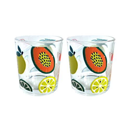 Angled view of a pair of clear glass tumblers, decorated with a colourful summer fruit design featuring papaya, lemon, and lime slices, and green pears.
