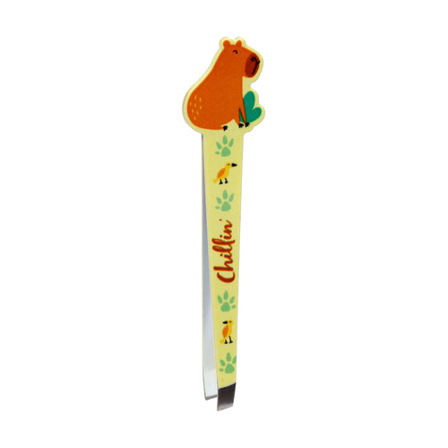 Light yellow tweezers with a capybara-shaped top, featuring an orange capybara illustration, green paw prints, yellow birds, and orange 'Chillin'' text, viewed from a slight angle showing the metallic gripping tips.