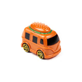 Angled view of an orange-brown toy hamburger truck, showing its front and side. It features a top shaped like a hamburger bun with white sesame seeds and green detailing, black windows, and black wheels with yellow spokes.