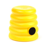 Yellow beehive pop-out toy with ribbed details and a black entrance, angled view.