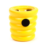 Angled view of a bright yellow ridged pop out toy beehive, with a black circular button visible on its side.