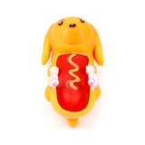 Stretchy yellow and orange dog fidget toy, designed as a hot dog, its belly open to reveal a red sausage with a yellow mustard squiggle. It features white paws with pink details, black eyes, and a brown nose.