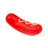 Angled view of a red hot dog sausage dog fidget toy, topped with yellow mustard lines, on a white background.