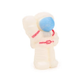 Angled front view of a translucent white astronaut figure from a hatching egg toy, featuring a textured blue visor and red suit details.